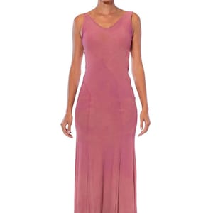 May include: A long, sleeveless, pink dress with a V-neckline. The dress is made of a soft, flowing fabric and has a simple, elegant design.