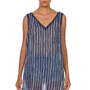 May include: A sleeveless, blue and white striped, sheer tunic top with a V-neckline and a beaded trim.