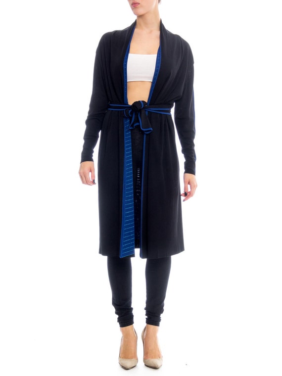 blue dress with black cardigan Soft morning light in San Diego Wearing a long baby blue dress with a black knit cardigan, lace gloves, strappy heels, a classic black hat, and structured black purse a