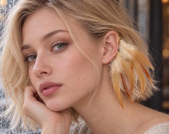 May include: A gold-toned ear cuff featuring a cluster of natural feathers in shades of cream, beige, and light brown. The accessory is designed to wrap around the cartilage of the ear, with the feathers hanging downwards along the side of the head.