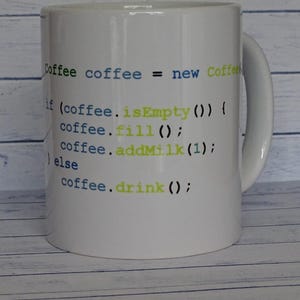 May include: A white ceramic mug featuring printed programming code in blue and lime green text. The code reads: Coffee coffee = new Coffee(); if (coffee.isEmpty()) { coffee.fill(); coffee.addMilk(1); } else { coffee.drink(); } with a handle.