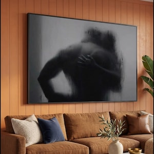 Puede incluir: Una pieza de arte mural rectangular que presenta una representación abstracta en blanco y negro de una espalda y hombro humanos con una mano apoyada sobre la piel. La obra se presenta en un marco negro fino, mostrando una estética borrosa.