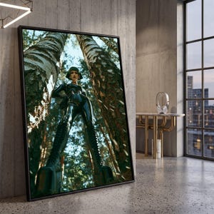 May include: A framed wall art print featuring a low-angle perspective of a person with short green hair wearing a black latex bodysuit and tall platform boots, standing between two tall birch trees in a forest setting with sunlight filtering through.