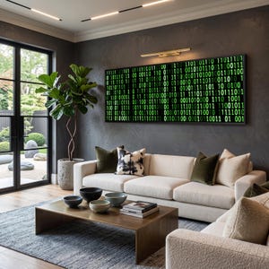 May include: A rectangular wall art piece featuring a glowing green binary code pattern on a black background, mounted above a cream-colored sofa with various throw pillows, a low wooden coffee table, and a large potted plant in a room.