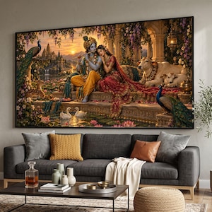 May include: A large rectangular wall art print depicting a scene with Krishna playing a flute while sitting beside Radha on a stone terrace. The image features a cow, a calf, two peacocks, and two swans in a lush garden setting at sunset.