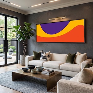 May include: A large rectangular wall art piece featuring a bold abstract design with a deep purple semi-circle, a vibrant yellow curved band, and a solid orange base, all enclosed within a thin black frame mounted above a white sofa.