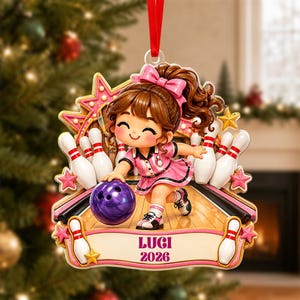 May include: A decorative Christmas ornament featuring a cartoon character bowling on a lane with white pins and a purple ball. The character wears a pink outfit with a matching bow. A banner at the bottom displays the text LUGI 2026.