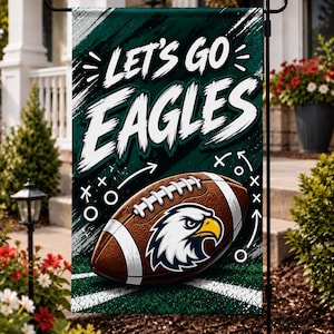 May include: A rectangular garden flag featuring a dark green background with white brushstroke accents. The text "LET'S GO EAGLES" appears in large white letters above a brown football with a white eagle head logo and white play diagrams.