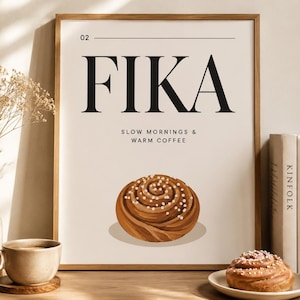 Pode incluir: Uma impressão de arte de parede emoldurada com o texto 02 FIKA SLOW MORNINGS & WARM COFFEE em letras pretas sobre um fundo creme, com uma ilustração central de um rolo de canela castanho coberto com cristais de açúcar brancos.