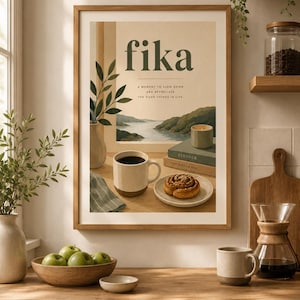Pode incluir: Uma impressão de arte de parede emoldurada com o texto fika e a moment to slow down and appreciate the good things in life. A ilustração mostra uma caneca de café, um rolinho de canela, uma vela e livros sobre uma mesa com vista.