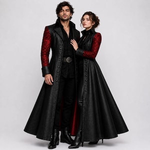 May include: Two long black coats featuring red lace sleeves and a row of small black buttons down the front. Each coat has a high collar, a flared skirt, and a solid black bodice. The coats are worn over black shirts and black trousers.