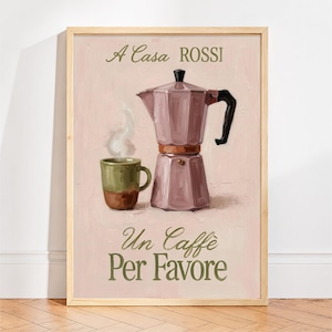 May include: A framed wall art print featuring a mauve moka pot and a green mug with steam rising, set against a light pink background. The text A Casa ROSSI is at the top, and Un Caffè Per Favore is at the bottom in dark green lettering.