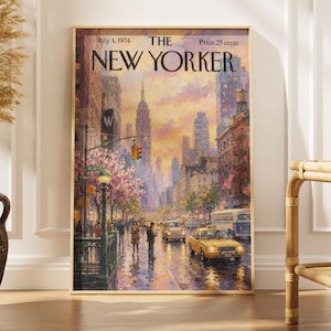 May include: A framed print of a New Yorker magazine cover dated July 1, 1974, featuring an impressionistic street scene of New York City. The artwork depicts a yellow taxi, a bus, pedestrians, and the Empire State Building under a sunset sky.