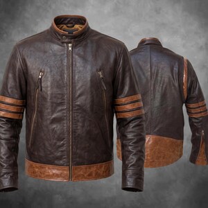 May include: A dark brown leather jacket featuring a stand-up collar, a full-length front zipper, and two vertical zippered chest pockets. The sleeves are accented with three horizontal tan stripes, and the hem is finished with a tan leather band.