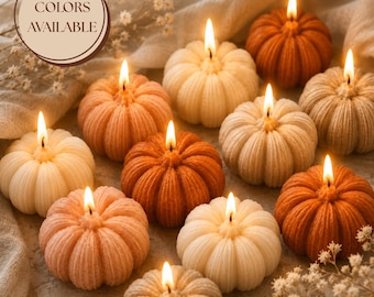 Puede incluir: Una colección de diez velas encendidas con forma de calabaza en varios tonos de naranja, crema y beige. Cada vela presenta una textura acanalada y una mecha encendida. Un gráfico circular con el texto COLORS AVAILABLE está arriba a la izquierda.