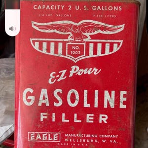 Può includere: Una tanica di benzina in metallo rosso vintage con testo e grafica bianchi. Presenta un emblema con aquila, la scritta E-Z Pour e indica una capacità di 2 galloni USA, 1,6 galloni imperiali e 7,570 litri. L'etichetta Eagle Manufacturing è visibile.