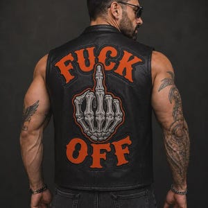 May include: A black leather waistcoat featuring a large embroidered patch on the back. The patch displays a grey skeletal hand making a middle finger gesture, surrounded by the orange text "FUCK" above and "OFF" below in a bold, stylised font.