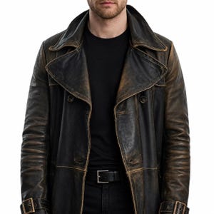 May include: A distressed black and brown leather trench coat featuring a wide lapel collar, double-breasted button closure, and buckled straps at the cuffs. The leather has a worn, vintage-inspired finish with visible colour variations throughout.