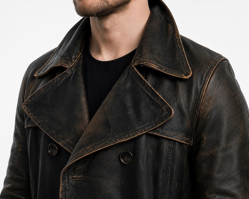 May include: A dark brown, distressed leather double-breasted coat featuring a wide notched lapel collar and dark circular buttons. The leather surface displays a weathered, multi-tonal finish with lighter brown highlights along the seams and edges.