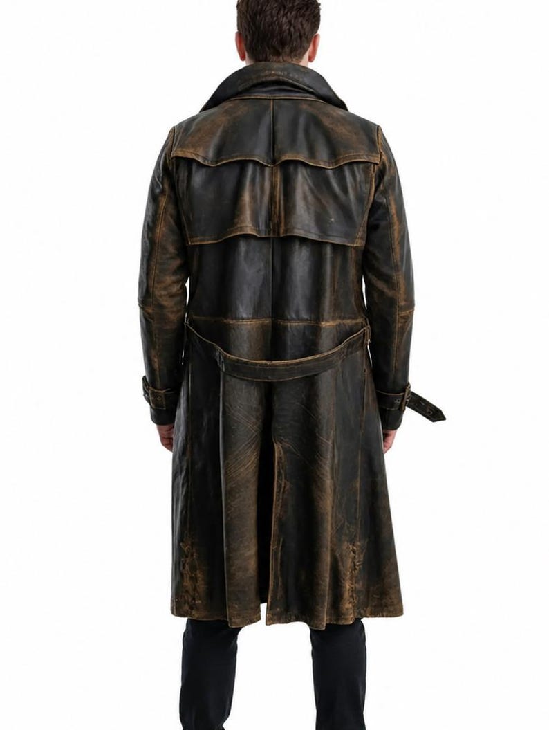 May include: A long, distressed dark brown leather trench coat featuring a wide collar, a back storm flap, and a matching waist belt with a buckle. The coat has long sleeves with buckled cuffs and a central back vent, showcasing a worn texture.