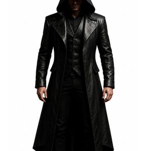May include: A black leather trench coat featuring a pointed hood, wide lapels, and long sleeves. The coat is worn over a matching black button-up vest and black trousers. The garment has a structured fit with a long, flowing hemline that reaches below the knees, creating a sleek, monochromatic appearance.