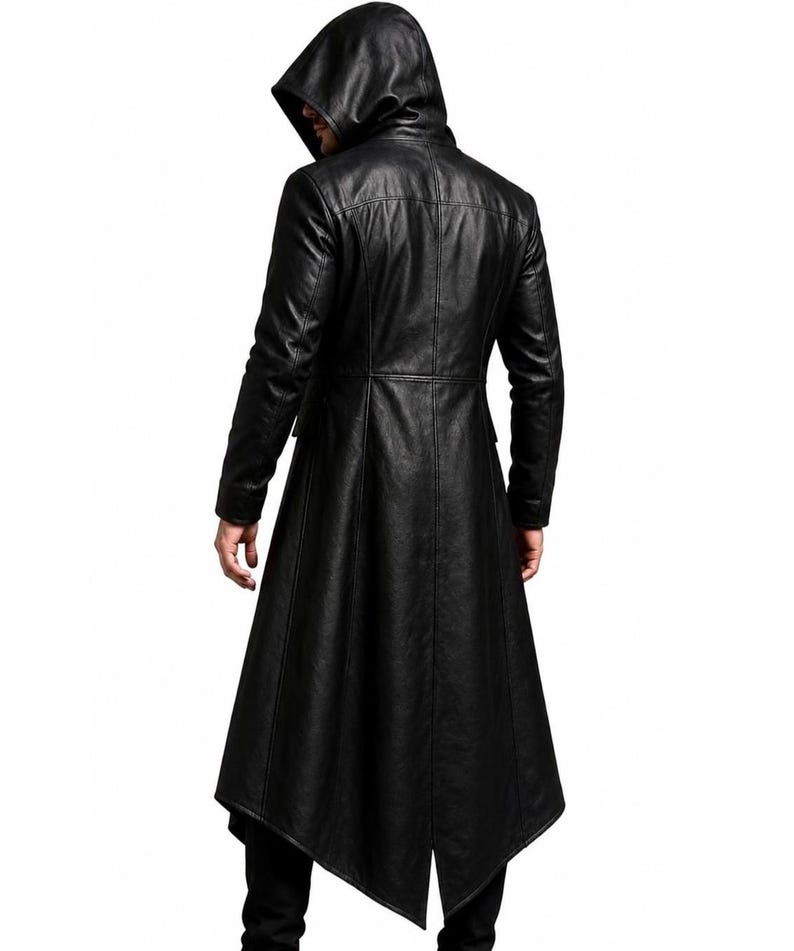 May include: A black long-length coat featuring a hood, long sleeves, and a structured fit. The garment is constructed with vertical seam detailing and a pointed, asymmetrical hemline that extends below the knees, crafted from a smooth material.
