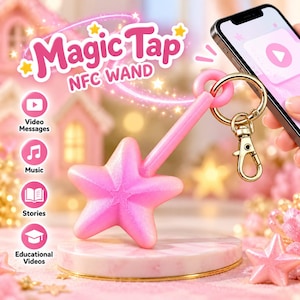 May include: A pink star-shaped NFC wand keychain with a gold-tone metal lobster clasp. The text Magic Tap NFC WAND is displayed above the wand, along with icons for video messages, music, stories, and educational videos on a pink background.