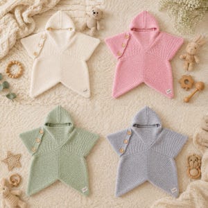 Puede incluir: Cuatro mantas para bebé con forma de estrella y capucha en color crema, rosa, verde salvia y azul claro. Cada manta tejida cuenta con una capucha, tres botones de madera en un lado y una pequeña etiqueta rectangular de marca en la punta.