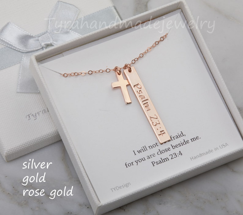 May include: Rose gold necklace with a cross charm and a bar pendant engraved with "Psalm 23:4" and the text "I will not be afraid, for you are close beside me. Psalm 23:4".