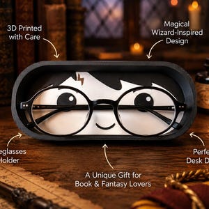 May include: An oval-shaped black spectacles holder featuring a white insert with a cartoon character design, including round black glasses, a lightning bolt scar, and a small smile. The holder displays text: 3D Printed with Care, Magical Wizard-Inspired Design, Eyeglasses Holder, and A Unique Gift for Book & Fantasy Lovers.