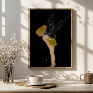 May include: A framed wall art print featuring a stylised illustration of a fairy with a yellow bun hairstyle, a green dress, and large, intricate, glowing wings with spiral patterns, set against a solid black background.