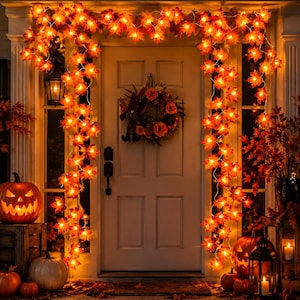 May include: A string of artificial maple leaf lights with glowing orange LEDs draped around a doorway. The garland features realistic autumn-colored foliage in shades of red, yellow, and orange, creating a warm, illuminated border for the entrance.