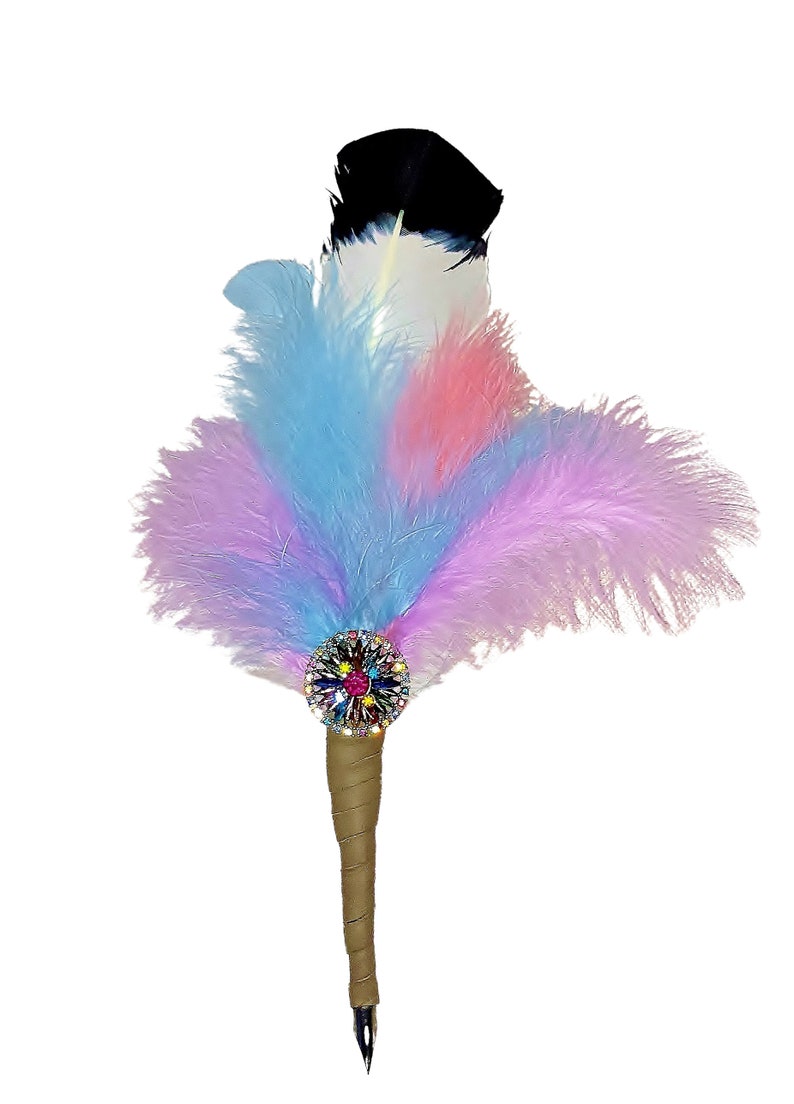 May include: A colorful feather pen with a jeweled embellishment. The pen has a black, white, pink, and blue feather plume. The pen is made of wood and has a metal nib.