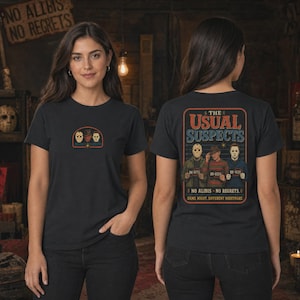 Puede incluir: Una camiseta negra con un peque&ntilde;o gr&aacute;fico en la parte delantera con tres m&aacute;scaras de personajes de pel&iacute;culas de terror. La parte trasera muestra un gr&aacute;fico grande con el texto THE USUAL SUSPECTS, tres personajes con carteles y NO ALIBIS NO REGRETS.