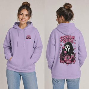 May include: A light purple hooded sweatshirt featuring a small graphic on the front and a large back print. The back design depicts a hooded figure holding a pink rotary phone with the text "SCREAM QUEEN DON'T HANG UP" in a dripping font.