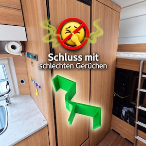 Könnte beinhalten: Eine leuchtend grüne Kunststoffhalterung mit gestuftem, kantigem Design vor einem Kühlschrank mit Holzoptik. Über der Halterung befindet sich ein gelbes Emoji mit einem roten Verbotszeichen und dem Text "Schluss mit schlechten Gerüchen".