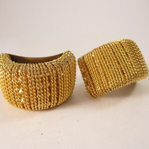 May include: A pair of gold-toned hoop earrings with a woven rope design.