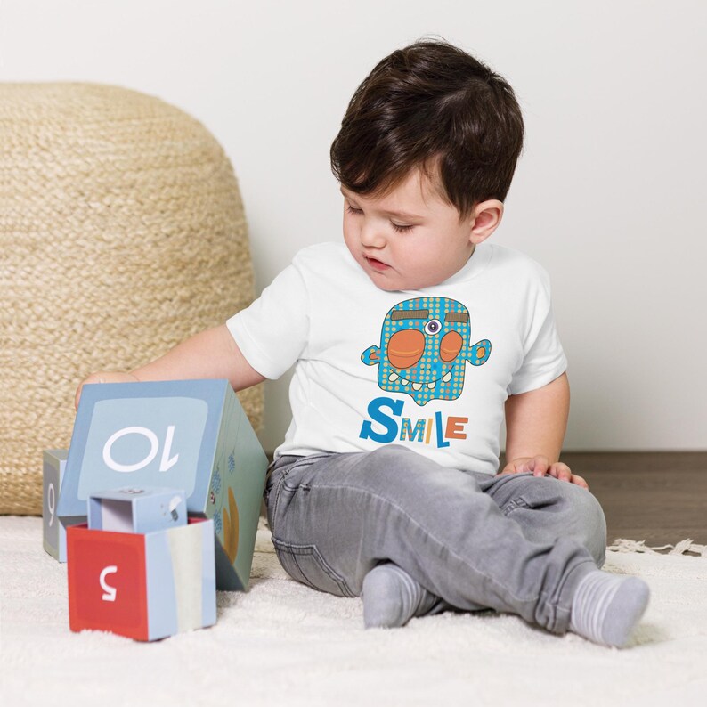 Kids Graphic Tee – SMILE Magu Shirt | Third-Eye Monster Character | Conscious Kids Clothing for the Whole Family | Toddler & Youth Gift