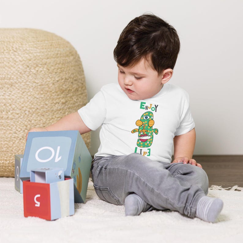 Kids Graphic Tee – ENJOY LIFE Magu Shirt | Third-Eye Monster Character | Joyful Conscious Kids Clothing for the Family | Toddler & Youth