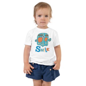 Kids Graphic Tee – SMILE Magu Shirt | Third-Eye Monster Character | Conscious Kids Clothing for the Whole Family | Toddler & Youth Gift