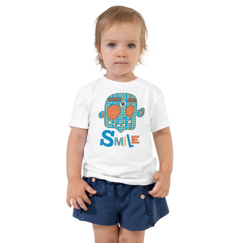 Kids Graphic Tee – SMILE Magu Shirt | Third-Eye Monster Character | Conscious Kids Clothing for the Whole Family | Toddler & Youth Gift