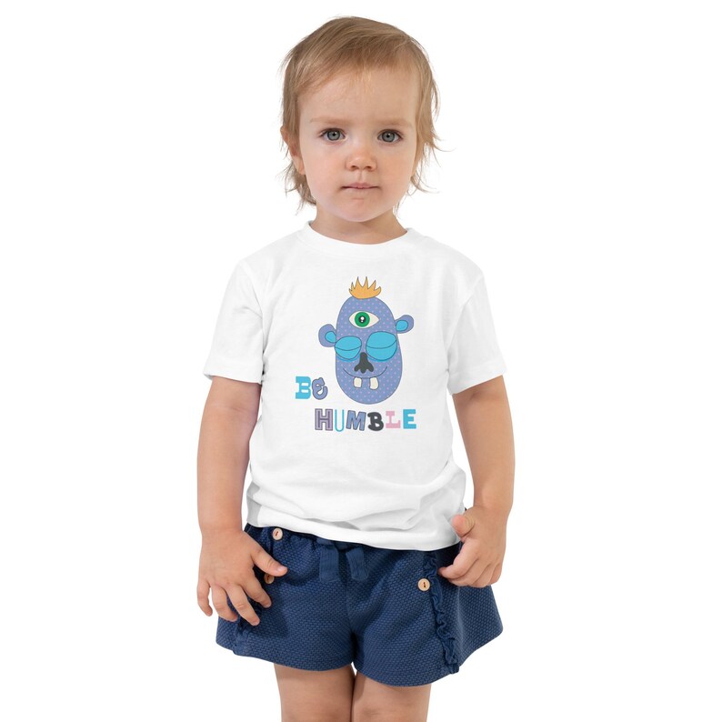Kids Graphic Tee – BE HUMBLE Magu Shirt | Third-Eye Monster Character | Conscious Kids Clothing for the Whole Family | Toddler & Youth Gift