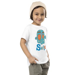 Kids Graphic Tee – SMILE Magu Shirt | Third-Eye Monster Character | Conscious Kids Clothing for the Whole Family | Toddler & Youth Gift