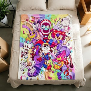 May include: A rectangular fleece blanket featuring a vibrant, multi-coloured graphic print of various cartoon characters, including a jester, a rabbit, and a toothy creature, set against a rainbow background with scattered confetti and star shapes.