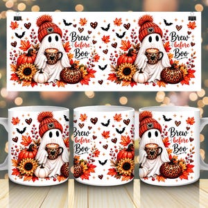 May include: Three white ceramic mugs featuring a repeating pattern of a ghost wearing a red knit hat, holding a leopard print coffee mug. The design includes orange pumpkins, sunflowers, red berries, autumn leaves, bats, and the text Brew before Boo.