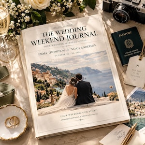 Könnte beinhalten: Ein Hochzeitsjournal mit dem Titel The Wedding Weekend Journal, den Namen Emma Thompson und Noah Anderson sowie dem Datum 28.-30. Oktober 2026. Das Cover zeigt ein Foto eines Paares mit Blick auf eine Küstenstadt und das Meer.