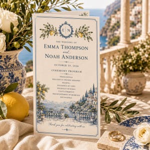 May include: A wedding ceremony program card featuring a blue and white Mediterranean coastal illustration, lemon branches, and the text: The Wedding of Emma Thompson and Noah Anderson, October 29, 2026, Ceremony Program, and order of events.