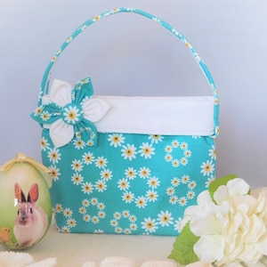Cartera para niñas con diseño de margaritas en color turquesa y blanco y broche de tela desmontable