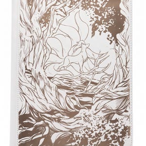 Peut inclure: Un classeur rectangulaire blanc orné d'une illustration au trait en bronze métallique représentant un renard à plusieurs queues dans une clairière. Le dessin détaillé montre des arbres stylisés, du feuillage et le renard aux queues fluides.