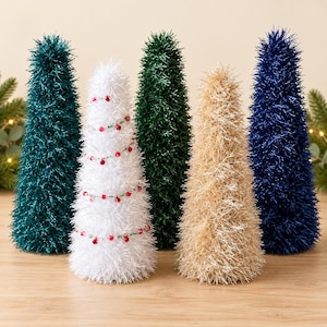 May include: A set of five cone-shaped decorative trees with a textured, tinsel-like finish. The collection includes colors of teal, white with red and green beaded garland, dark green, gold, and navy blue, all standing in a row.